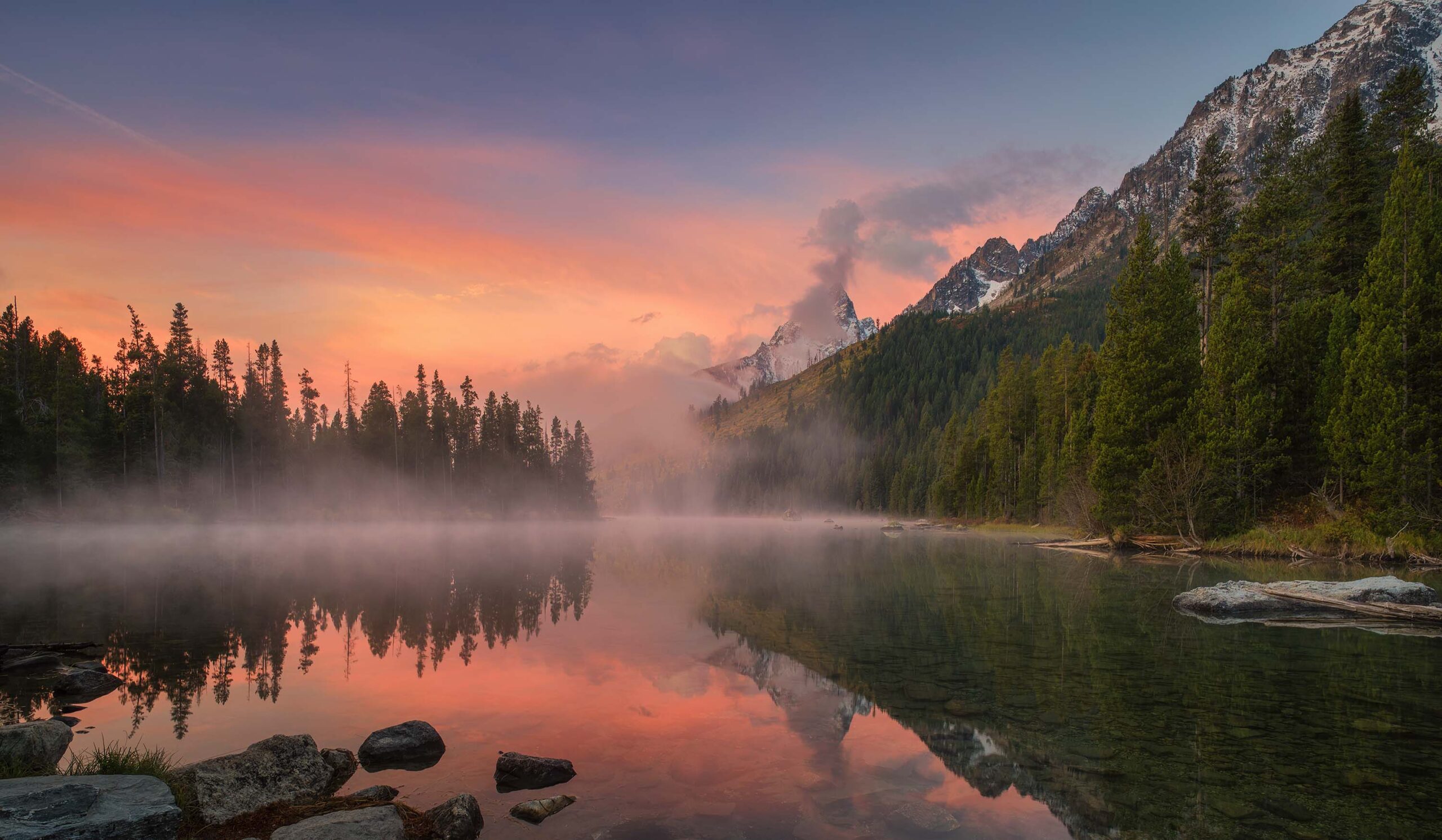 Fine art landschapsfotografie van de Grand Tetons bij zonsopkomst, met bergtoppen, mist en reflecties in het water