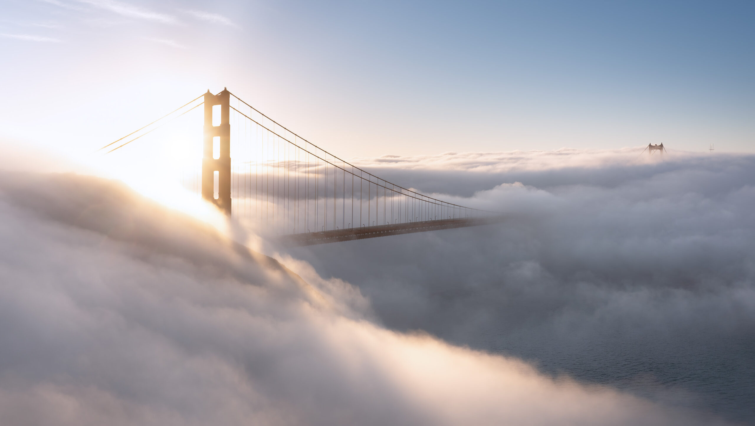 Golden Gate Bridge steekt boven de mist uit bij zonsopkomst in San Francisco